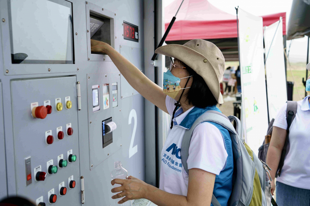 志工們將拾起的寶特瓶投入「好歸塑專車」，讓廢棄塑料空瓶可以直接粉碎、縮小體積，未來將可再製成購物袋、寶特衣、悠遊卡等生活用品